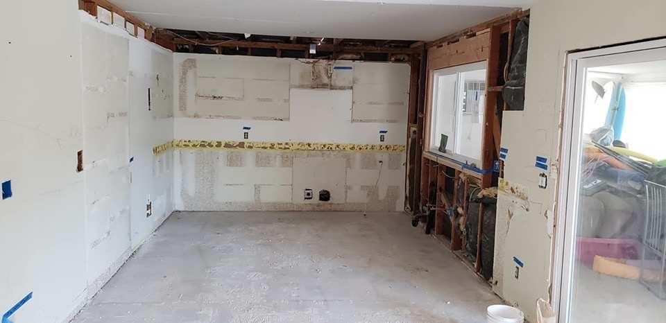 Kitchen demolition with gutted walls and exposed framing — Orange County CA